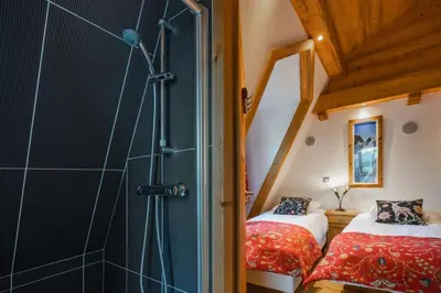 a bathroom with a shower and two beds in a room at Astoria - UltraCentral 140m2 Balcons Vues Balneo Sauna in Chamonix-Mont-Blanc