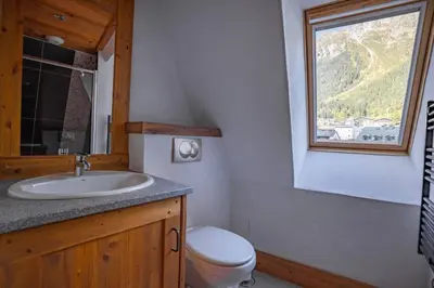 a bathroom with a sink and a toilet and a window at Astoria - UltraCentral 140m2 Balcons Vues Balneo Sauna in Chamonix-Mont-Blanc