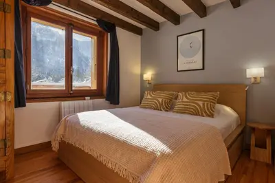 a bedroom with a bed and a window at Cyclamens - Cosy Chalet 500m Flegere Cheminee Vue Garage in Chamonix-Mont-Blanc