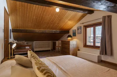 a bedroom with a bed and a wooden ceiling at Cyclamens - Cosy Chalet 500m Flegere Cheminee Vue Garage in Chamonix-Mont-Blanc