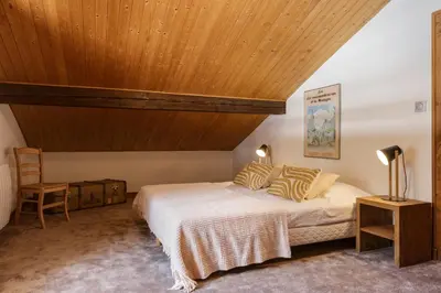 a bedroom with a bed and a wooden ceiling at Cyclamens - Cosy Chalet 500m Flegere Cheminee Vue Garage in Chamonix-Mont-Blanc