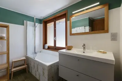 a bathroom with a tub and a sink and a mirror at Cyclamens - Cosy Chalet 500m Flegere Cheminee Vue Garage in Chamonix-Mont-Blanc