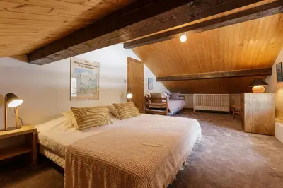 a bedroom with a large bed and a wooden ceiling at Cyclamens - Cosy Chalet 500m Flegere Cheminee Vue Garage in Chamonix-Mont-Blanc
