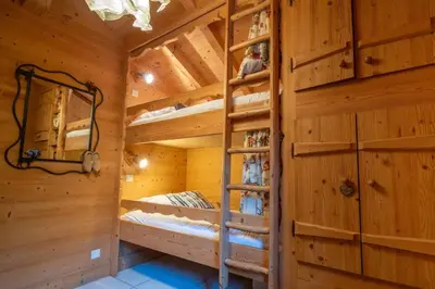 a log cabin bedroom with bunk beds in it at Glaciers Chalet Cheminee Vue Confort Calme in Les Houches
