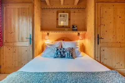 a bedroom with a bed in a wooden room at Glaciers Chalet Cheminee Vue Confort Calme in Les Houches