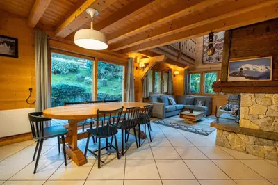 a dining room and living room with a table and chairs at Glaciers Chalet Cheminee Vue Confort Calme in Les Houches