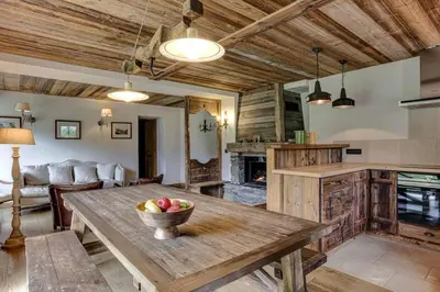 a kitchen and living room with a wooden table at Gublin - Apart Famille Vue360 Nature Calme Cheminee in Les Houches