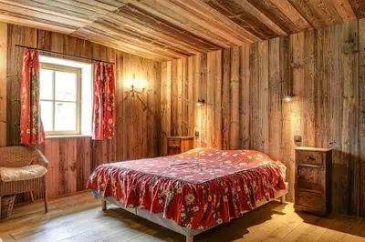 a bedroom with a bed in a room with wooden walls at Gublin - Apart Famille Vue360 Nature Calme Cheminee in Les Houches