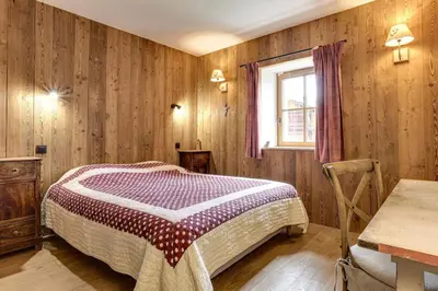 a bedroom with a bed and a table and a window at Gublin - Apart Famille Vue360 Nature Calme Cheminee in Les Houches