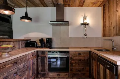 a kitchen with wooden cabinets and a sink at Gublin - Apart Famille Vue360 Nature Calme Cheminee in Les Houches