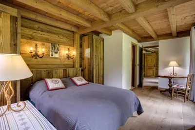 a bedroom with a bed in a room with wooden walls at Prarion - Chalet Familial Vue360 Nature Calme Unique in Les Houches