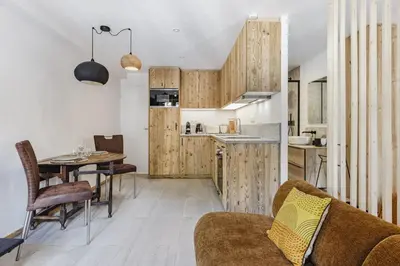 a living room with a couch and a table and a kitchen at Balmat - UltraCentral 2pax Confort Vue Quartier Vivant in Chamonix-Mont-Blanc