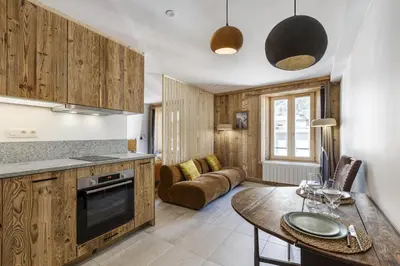 a kitchen and living room with a table and a couch at Balmat - UltraCentral 2pax Confort Vue Quartier Vivant in Chamonix-Mont-Blanc