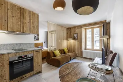 a kitchen and living room with a table and a couch at Balmat - UltraCentral 2pax Confort Vue Quartier Vivant in Chamonix-Mont-Blanc