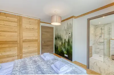 a bedroom with a shower and a bed with towels at Couchant Chalet Lumineux 6pax Vues Terrasses Confort in Chamonix-Mont-Blanc