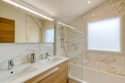 a white bathroom with a sink and a shower at Couchant Chalet Lumineux 6pax Vues Terrasses Confort in Chamonix-Mont-Blanc