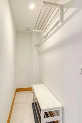 a white room with a shelf and a staircase at Couchant Chalet Lumineux 6pax Vues Terrasses Confort in Chamonix-Mont-Blanc