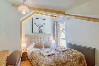 a bedroom with a bed with two towels on it at Couchant Chalet Lumineux 6pax Vues Terrasses Confort in Chamonix-Mont-Blanc
