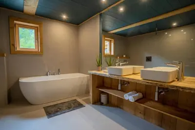 a bathroom with two sinks and a bath tub at Eden Chalet Spacieux Vues Jacuzzi Cheminee BBQ in Chamonix-Mont-Blanc