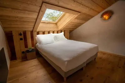 a bedroom with a large white bed with a window at Eden Chalet Spacieux Vues Jacuzzi Cheminee BBQ in Chamonix-Mont-Blanc