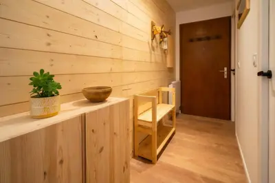 a room with a wooden wall with a table and a chair at Sapi Cocon 4pax Centre Jardin Remontees TV Wifi in Chamonix-Mont-Blanc