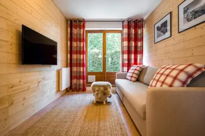 a living room with a couch and a tv at Sapi Cocon 4pax Centre Jardin Remontees TV Wifi in Chamonix-Mont-Blanc