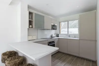 a kitchen with white cabinets and a white counter top at Levant Chalet Moderne 6pax Vues Terrasses Confort in Chamonix-Mont-Blanc