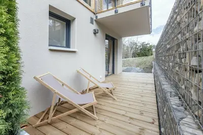 two chairs on a wooden deck next to a building at Levant Chalet Moderne 6pax Vues Terrasses Confort in Chamonix-Mont-Blanc
