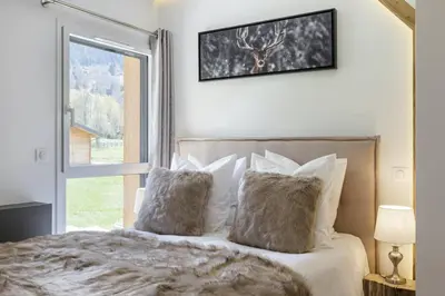 a bedroom with a bed with pillows and a window at Levant Chalet Moderne 6pax Vues Terrasses Confort in Chamonix-Mont-Blanc