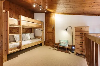 a bedroom with two bunk beds and a desk at Argentero Cosy Duplex Pied Pistes Vue Grands Montets in Chamonix-Mont-Blanc