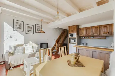 a kitchen and living room with a table and a couch at Argentero Cosy Duplex Pied Pistes Vue Grands Montets in Chamonix-Mont-Blanc
