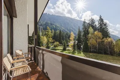 a balcony with chairs and a view of the mountains at Argentero Cosy Duplex Pied Pistes Vue Grands Montets in Chamonix-Mont-Blanc