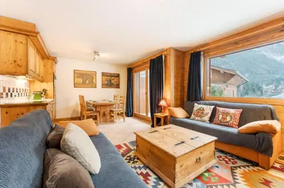 a living room with a couch and a table at Etoile Cosy Balcon Vue Montagne Proche Centre in Chamonix-Mont-Blanc