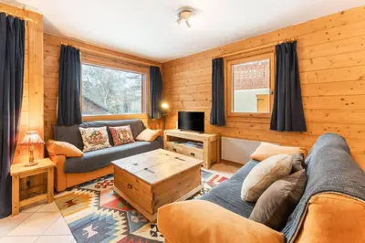 a living room with a couch and a table at Etoile Cosy Balcon Vue Montagne Proche Centre in Chamonix-Mont-Blanc