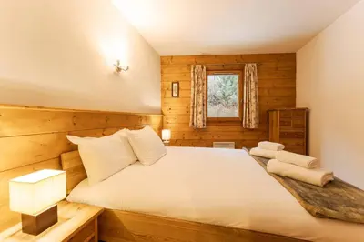 a bedroom with a large white bed in a cabin at Etoile Cosy Balcon Vue Montagne Proche Centre in Chamonix-Mont-Blanc