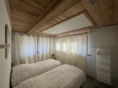 a bedroom with two beds and a ceiling with a window at Chalet Sablod in Les Contamines-Montjoie