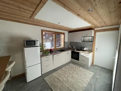 a kitchen with white appliances and a wooden ceiling at Chalet Sablod in Les Contamines-Montjoie