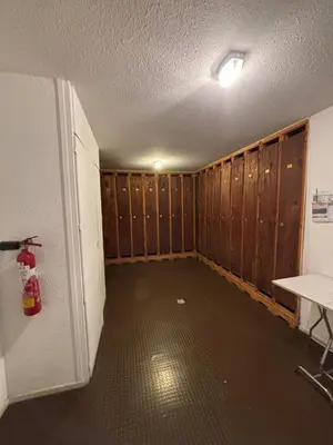 an empty room with wooden walls and a room with a refrigerator at Cocon Saint-Gervais in Saint-Gervais-les-Bains