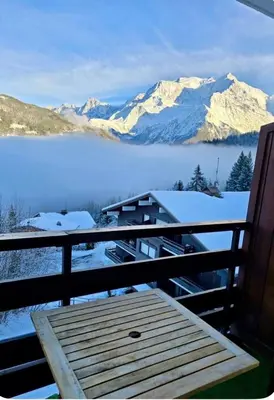 a balcony with a view of a lake and snow covered mountains at Cocon Saint-Gervais in Saint-Gervais-les-Bains
