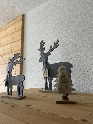 two wooden figurines of a woman and deer on a shelf at Cocon Saint-Gervais in Saint-Gervais-les-Bains