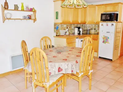 a kitchen with a table and chairs and a white refrigerator at Duplex à Samoëns, 6 pers, balcon sud, parking - FR-1-815-48 in Samoëns