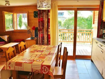 a dining room with a table and a balcony at Appartement neuf 3 pièces - 6 pers - Vue montagne - FR-1-815-49 in Samoëns