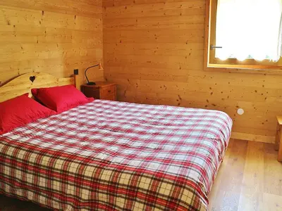 a bedroom with a bed with a plaid blanket at Appartement neuf 3 pièces - 6 pers - Vue montagne - FR-1-815-49 in Samoëns