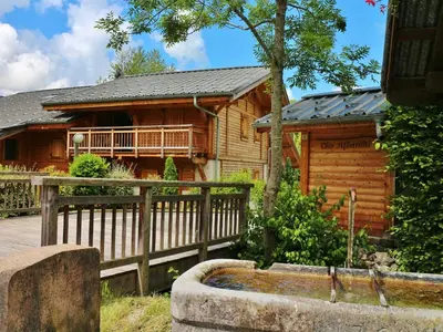 a log cabin with a wooden fence and a fountain at Appartement neuf 3 pièces - 6 pers - Vue montagne - FR-1-815-49 in Samoëns