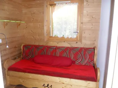 a red couch in a wooden room with a window at Appartement neuf 3 pièces - 6 pers - Vue montagne - FR-1-815-49 in Samoëns