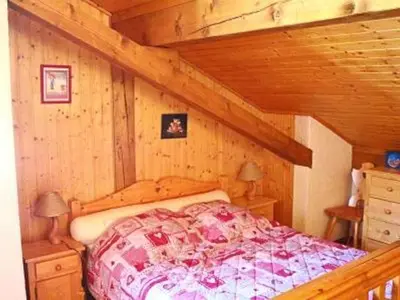 a bedroom with a bed in a wooden cabin at Charmant appartement à Samoëns pour 8 pers avec balcon - FR-1-815-112 in Samoëns