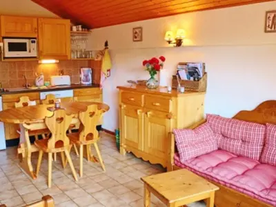 a kitchen and dining room with a table and a couch at Charmant appartement à Samoëns pour 8 pers avec balcon - FR-1-815-112 in Samoëns