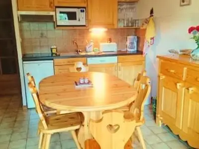 a wooden table and chairs in a kitchen at Charmant appartement à Samoëns pour 8 pers avec balcon - FR-1-815-112 in Samoëns