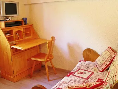 a bedroom with a desk and a chair and a bed at Charmant appartement à Samoëns pour 8 pers avec balcon - FR-1-815-112 in Samoëns