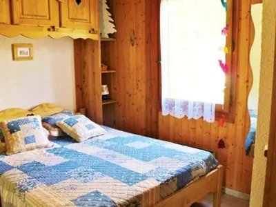 a bedroom with a bed with a blue quilt at Charmant appartement à Samoëns pour 8 pers avec balcon - FR-1-815-112 in Samoëns